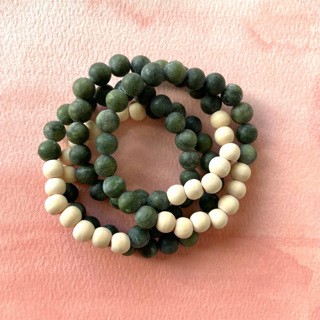 Handmade gemstone stacking bracelet made with green jade and wood beads. Designed to diffuse essential oils, this bracelet is perfect for attracting luck, prosperity, and positivity. Adjustable, durable, and stylish for everyday wear. Ideal gift for those seeking balance and good fortune.