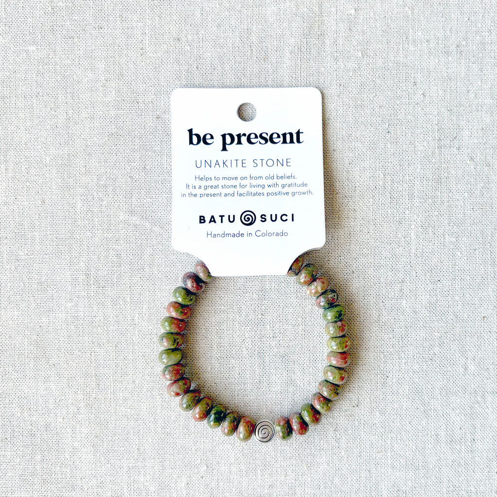 “Be Present” rondelle gemstone bracelet — handmade mindfulness jewelry by Batu Suci, crafted with smooth natural stones that encourage calm, focus, and inner balance. A gentle reminder to slow down and live in the moment. This handcrafted elastic bracelet is perfect for meditation, yoga, or everyday wear. Designed in Colorado, it makes a meaningful self-care or grounding gift for anyone seeking peace and presence.
