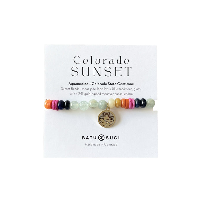 Handmade Colorado Sunset Bracelet featuring Aquamarine, Topaz Jade, Lapis Lazuli, and Blue Sandstone beads, accented with a gold-dipped zinc alloy sunset charm, inspired by Colorado's vibrant sunsets. Handmade in Colorado.