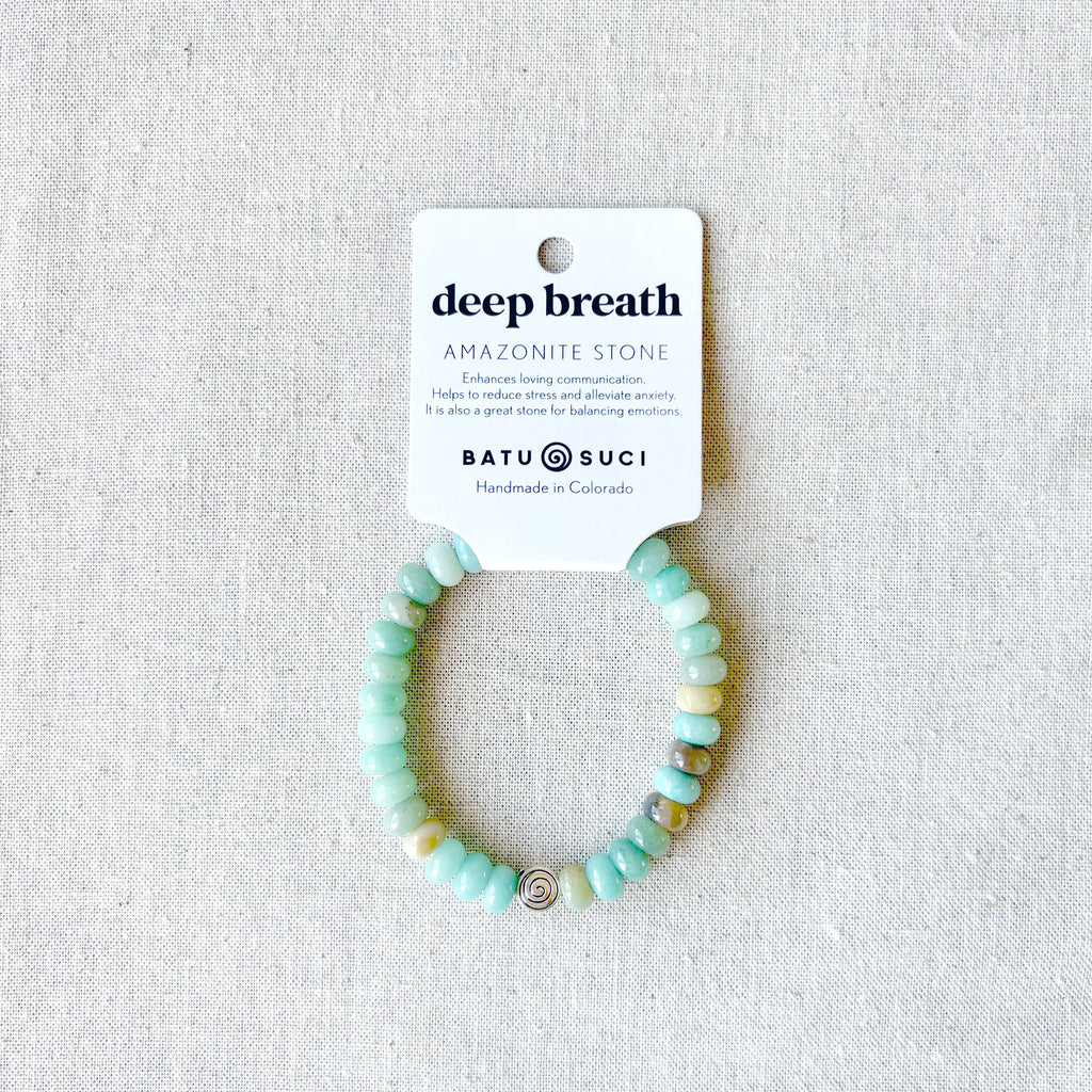 “Deep Breath” Amazonite rondelle bracelet — handmade calming gemstone jewelry from Batu Suci, featuring soothing aqua-toned Amazonite stones known for peace, balance, and emotional clarity. A wearable reminder to pause, breathe deeply, and release tension. This handcrafted elastic bracelet pairs beautifully with essential oils for natural stress relief and mindfulness. Designed in Colorado, it makes a thoughtful gift for anyone seeking serenity and self-care.