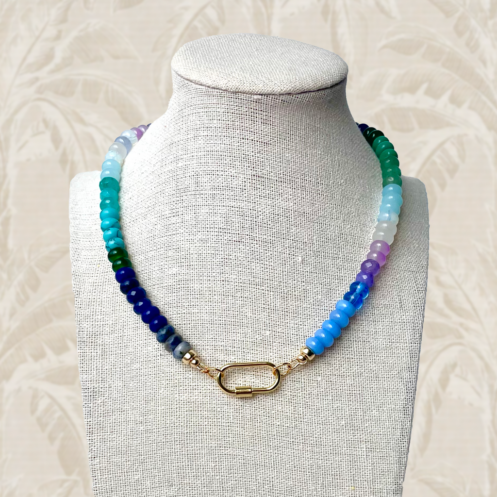 Elegant, handmade, Ocean Aura gemstone necklace featuring ocean blues, lush greens, and mystical purples in vibrant beads, accented with gold-plated details and a versatile gold carabiner closure for two distinct wearing styles.