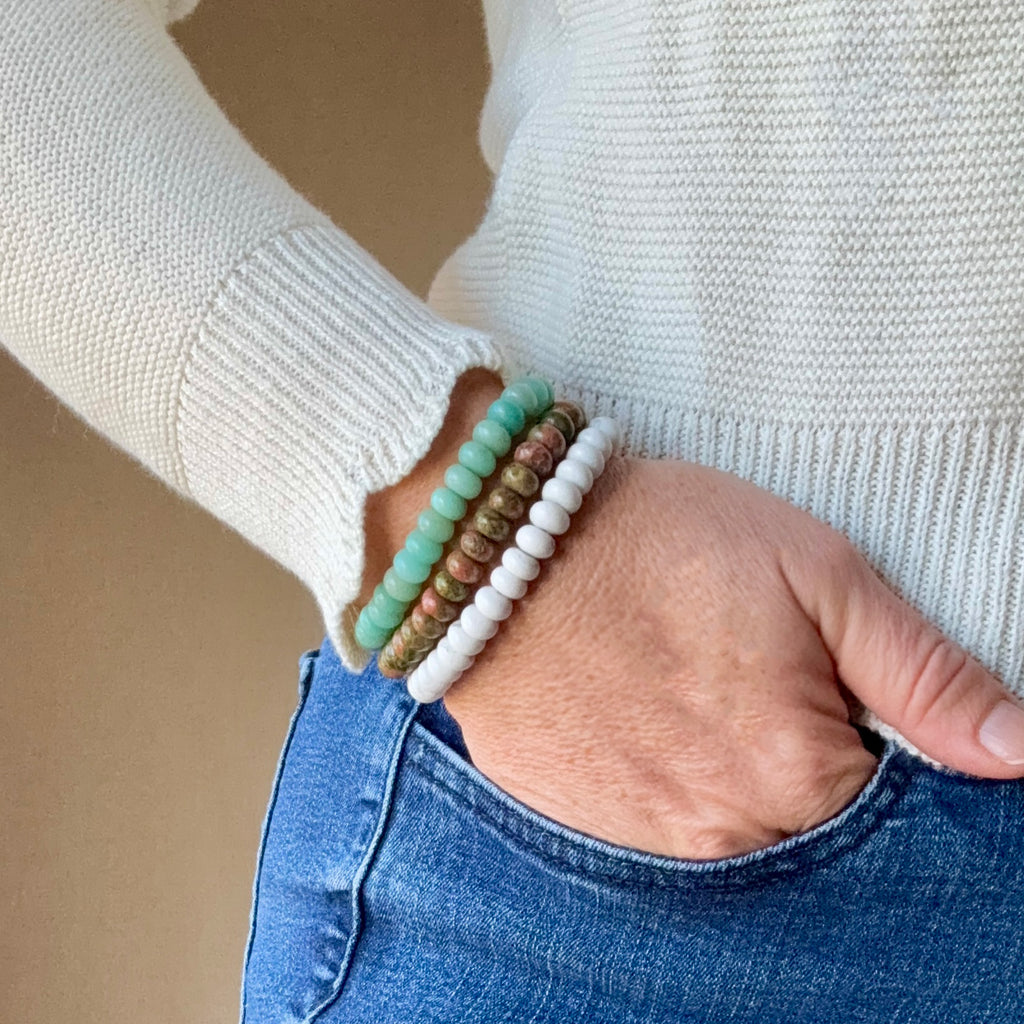 Rondelle gemstone bracelets — handmade mindfulness jewelry by Batu Suci, crafted with smooth natural stones that encourage calm, focus, and inner balance. A gentle reminder to slow down and live in the moment. This handcrafted elastic bracelet is perfect for meditation, yoga, or everyday wear. Designed in Colorado, it makes a meaningful self-care or grounding gift for anyone seeking peace and presence. Amazonite, Unakite, and Howlite gemstones.