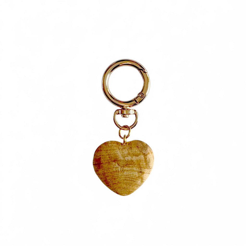 Hand-carved Palo Santo Heart Bag Charm on gold-plated swivel clip keychain, sustainably sourced from Peru.