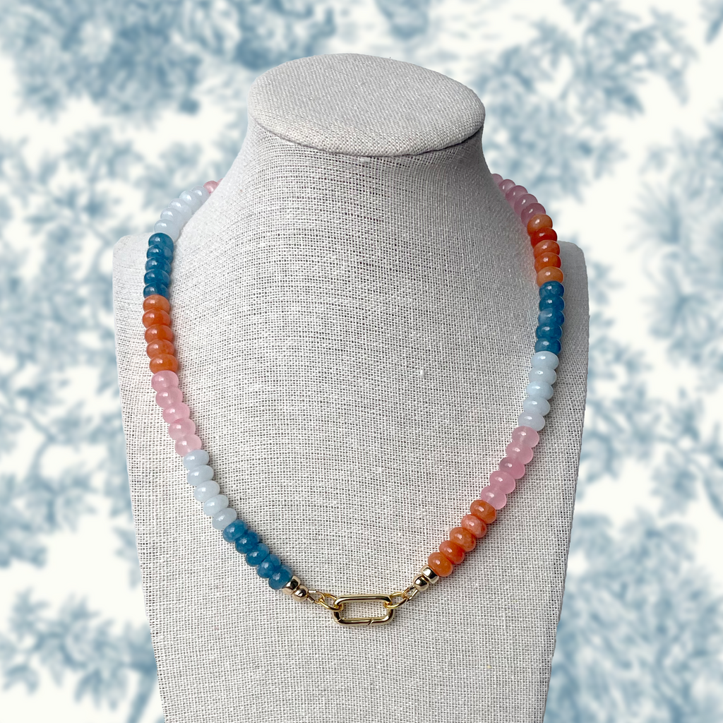 Sunset Sorbet necklace featuring a vibrant mix of pink, orange, aqua, and blue rondelle gemstone beads with gold accents and a gold carabiner clasp, inspired by the colors of a summer sunset.