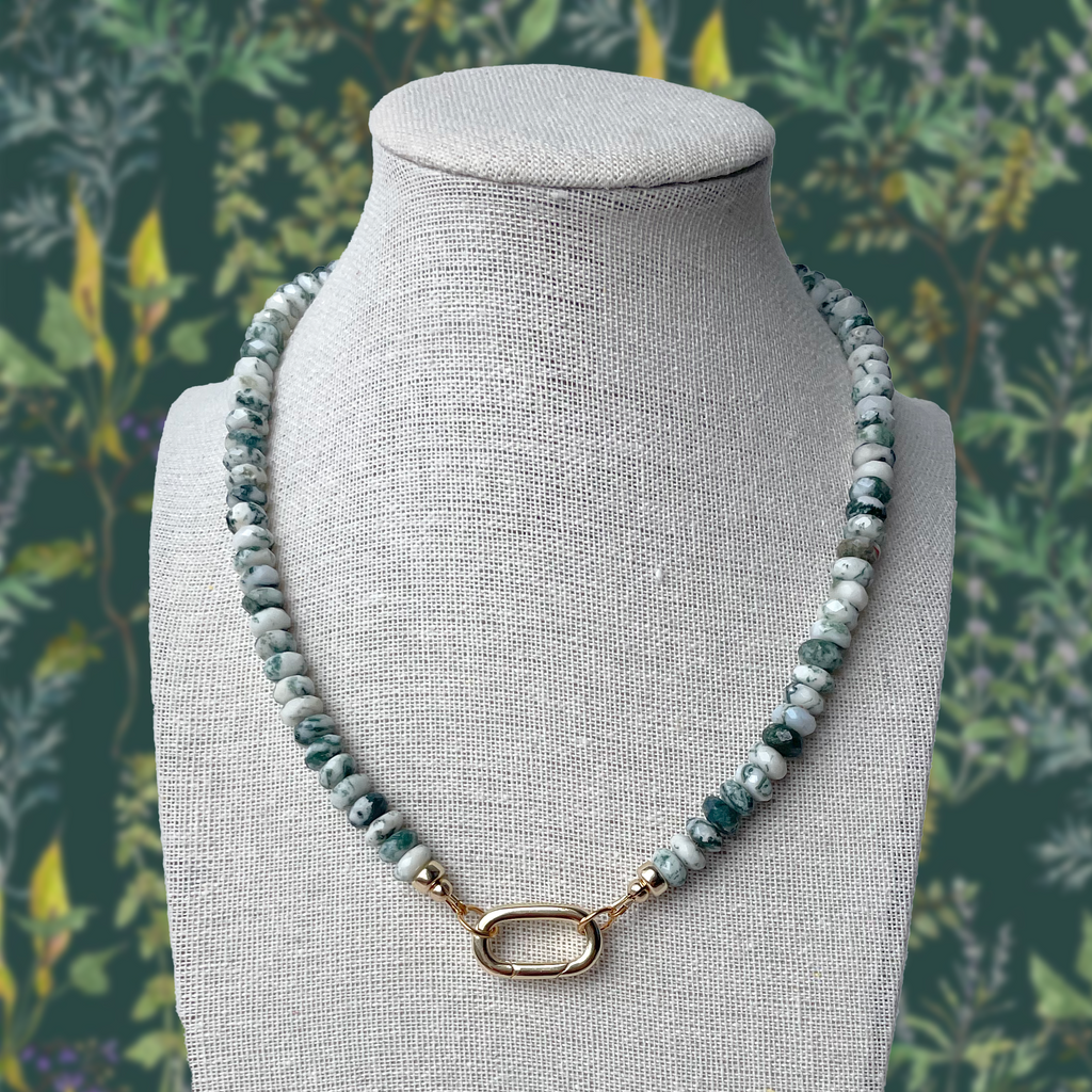 Tree Jasper gemstone necklace featuring earthy green and white beads with unique natural patterns, accented with elegant gold details and a carabiner clip clasp, inspired by the beauty and balance of nature.